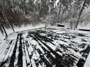 Tumedat värvi lamekatus puhastatud raskest lumest