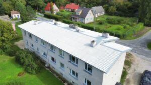 Pilt heledast kortermajast Eestis. Paigaldatud uus hele eterniit katus koos plekk turvalisanditega.